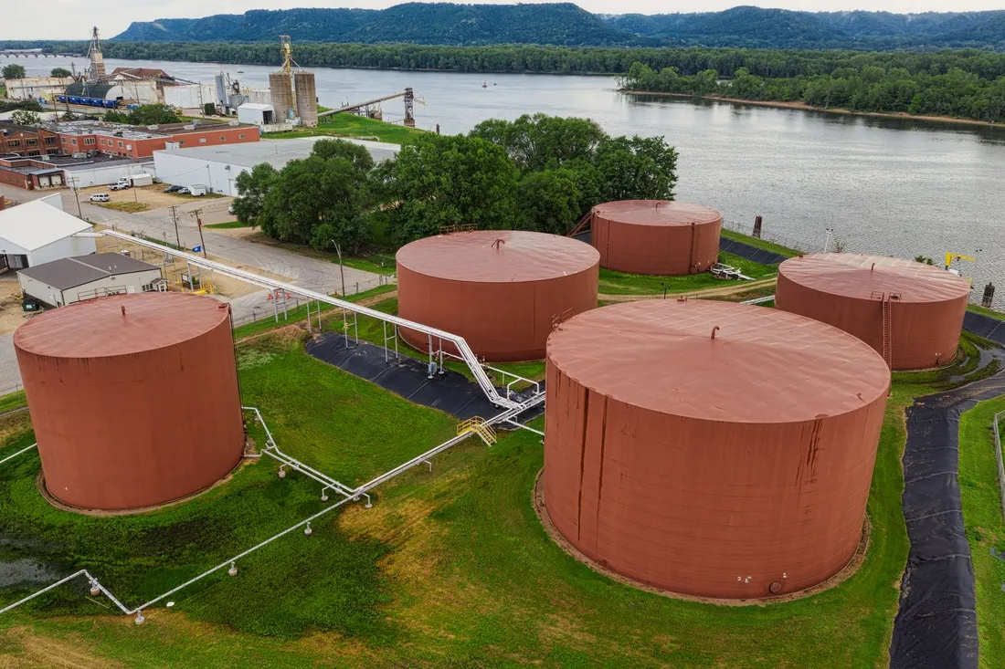Aerial photograph of cylindrical storage tanks beside a river