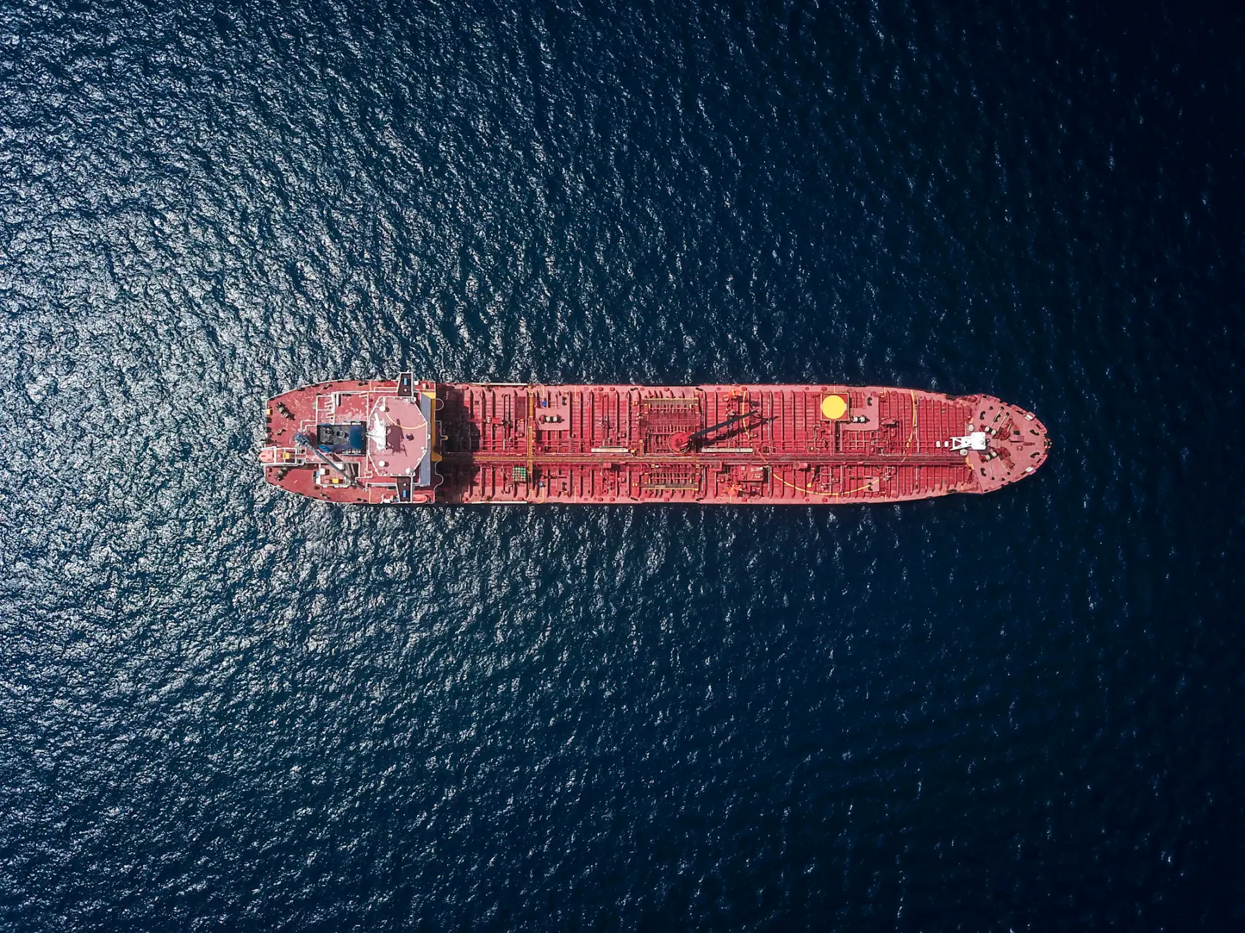 Aerial photograph of a petroleum tanker moving across deep blue water